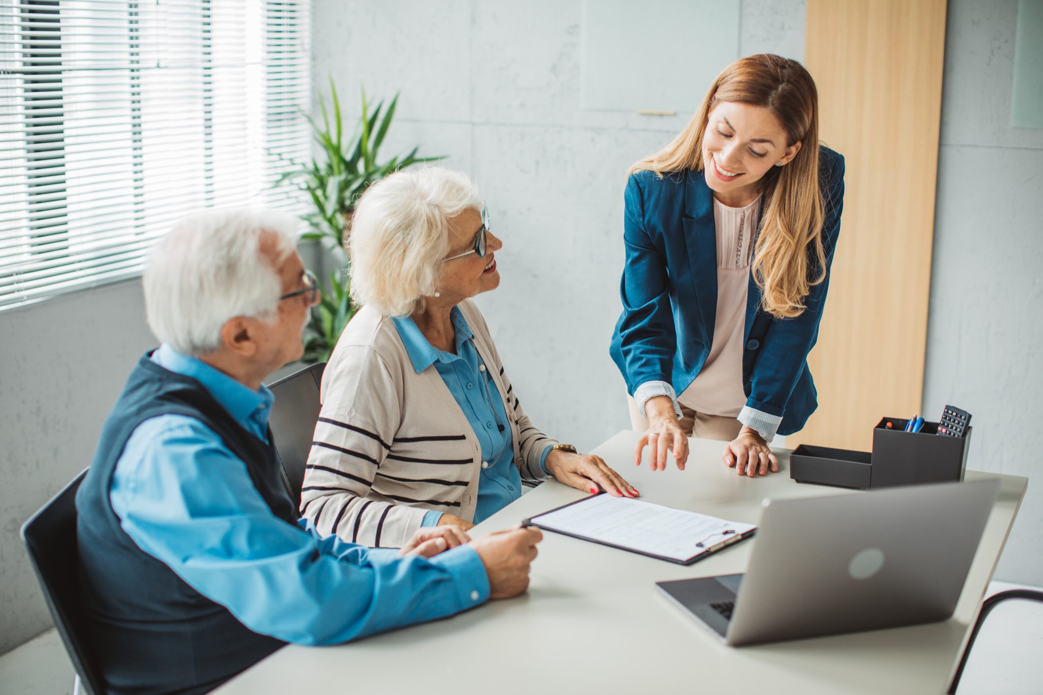 Woman explaining document to elderly couple.